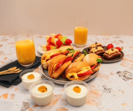 Breakfast rolls, yoghurt, cake, fruit skewers and juice.