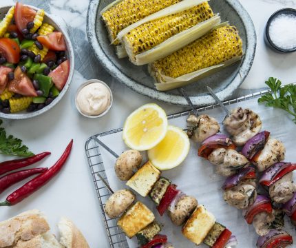 Events Catering Melbourne spread of food, including corn, salad and barbecued mushroom/chicken skewers.