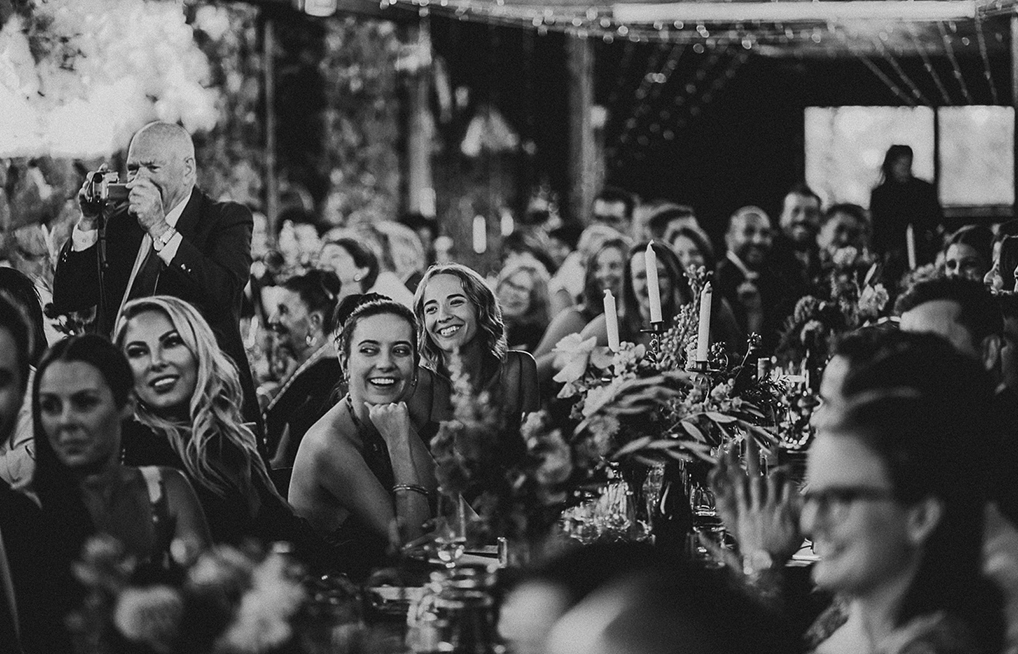 Black and white image of smiling wedding attendees. Wedding catering Melbourne